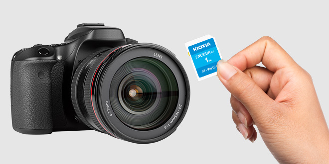 Sosteniendo una tarjeta SD EXCERIA G2 delante de una cámara DSLR