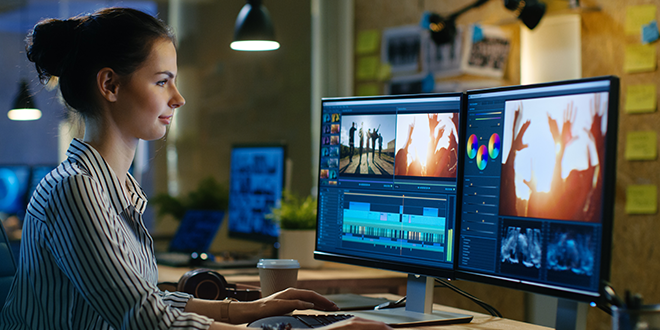 A young woman editing a video on a PC